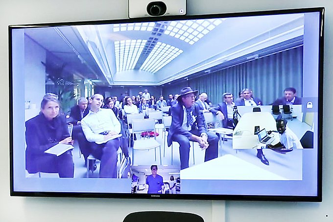 videosamtalsbild på en åhörarskara i ett konferensrum i Stockholm