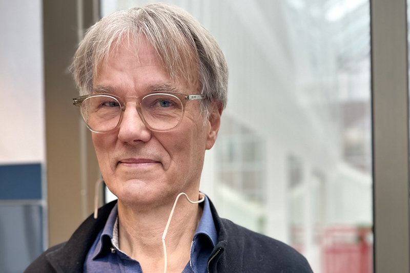 Närbild på en person i ljust hår, glasögon och plirig blick