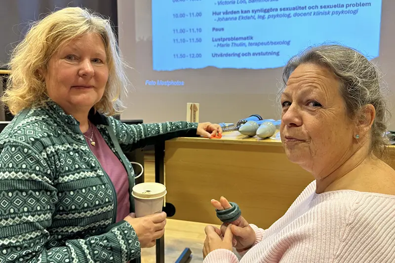 Två personer ler in i kameran.