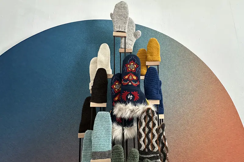 Ett vantträd med diverse färgglada vantar i olika stil och material