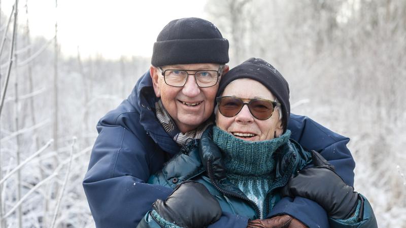 Glatt penisionärspar utomhus en vinterdag.