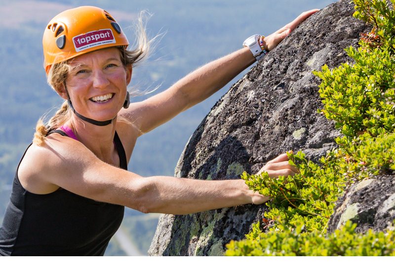 en kvinna klättrar på en klippa