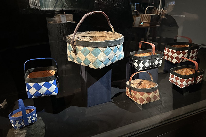En samling gamla målade korgar bakom glas