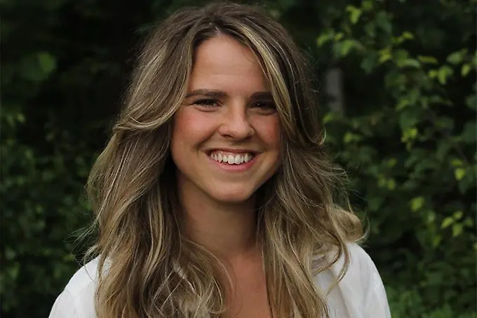 En leende person i sommarmiljö