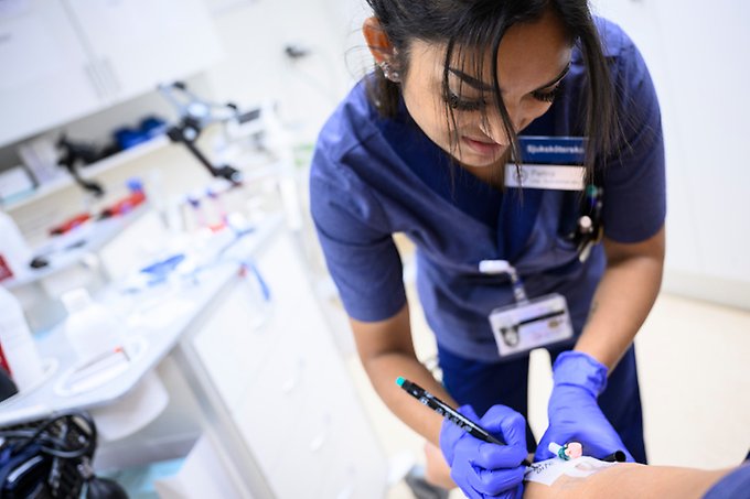 En sjuksköterska undersöker en patients arm.