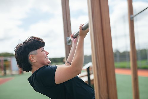 Kvinna tränar på ett ute-gym.