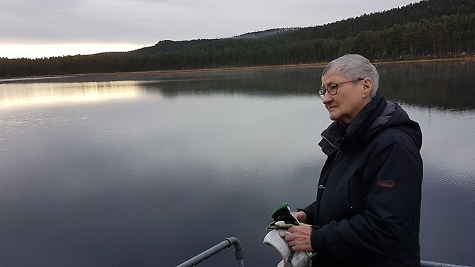 Silversmeden Kerstin Öhlin Lejonklou fotad i solnedgång vid en sjö.